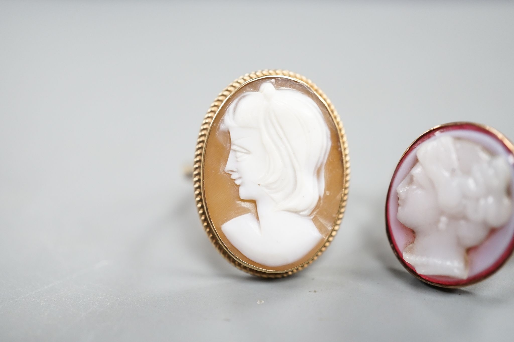 Two 9ct and oval cameo shell set rings, each carved with the bust of a lady to dexter, gross 5.9 grams.
